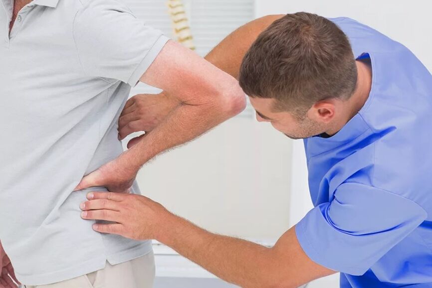 A patient with lower back pain at a diagnostic examination by a doctor